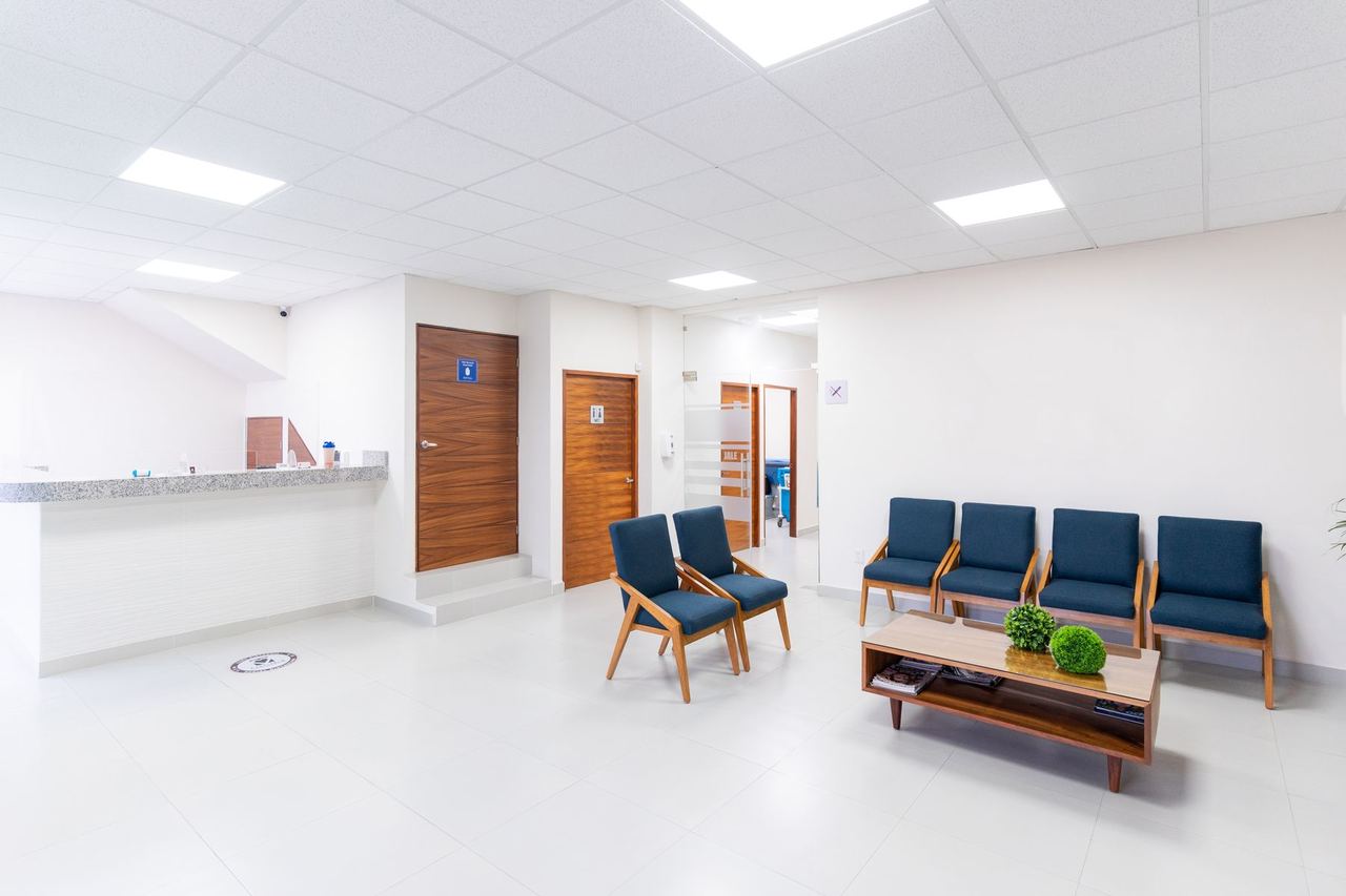 Salle d'attente lumineuse et propre, avec des fauteuils bleus et une table basse