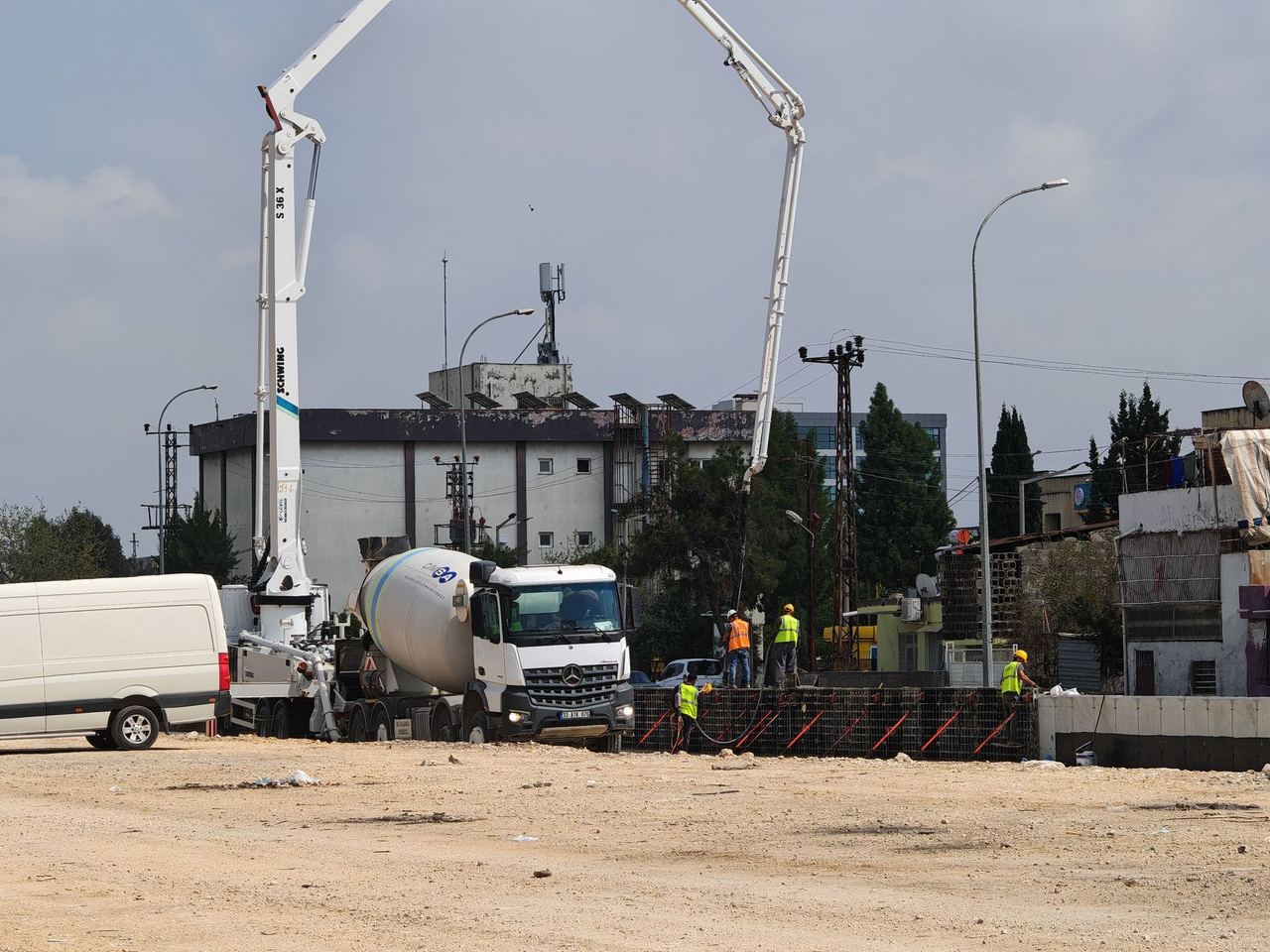 Pompe à béton et camion malaxeur sur un grand chantier en ville