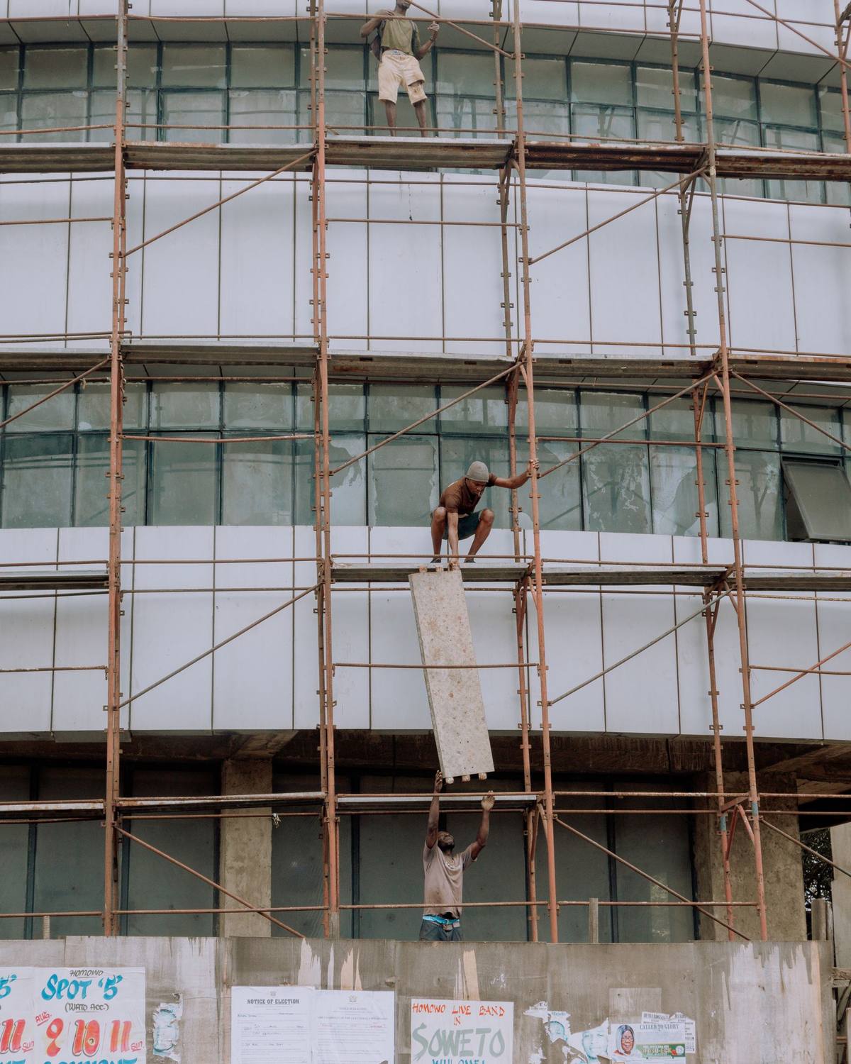 Ouvriers sur un échafaudage le long de la façade d'un immeuble de plusieurs étages
