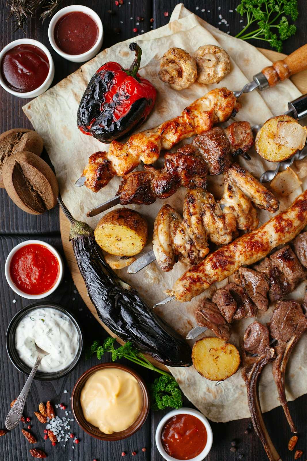Assortiment de brochettes, poissons grillés et sauces vu du dessus