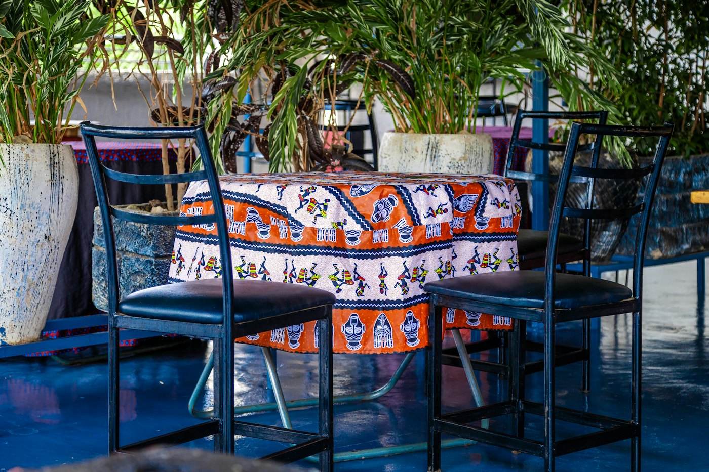 Table dressée avec une nappe colorée, entourée de plantes