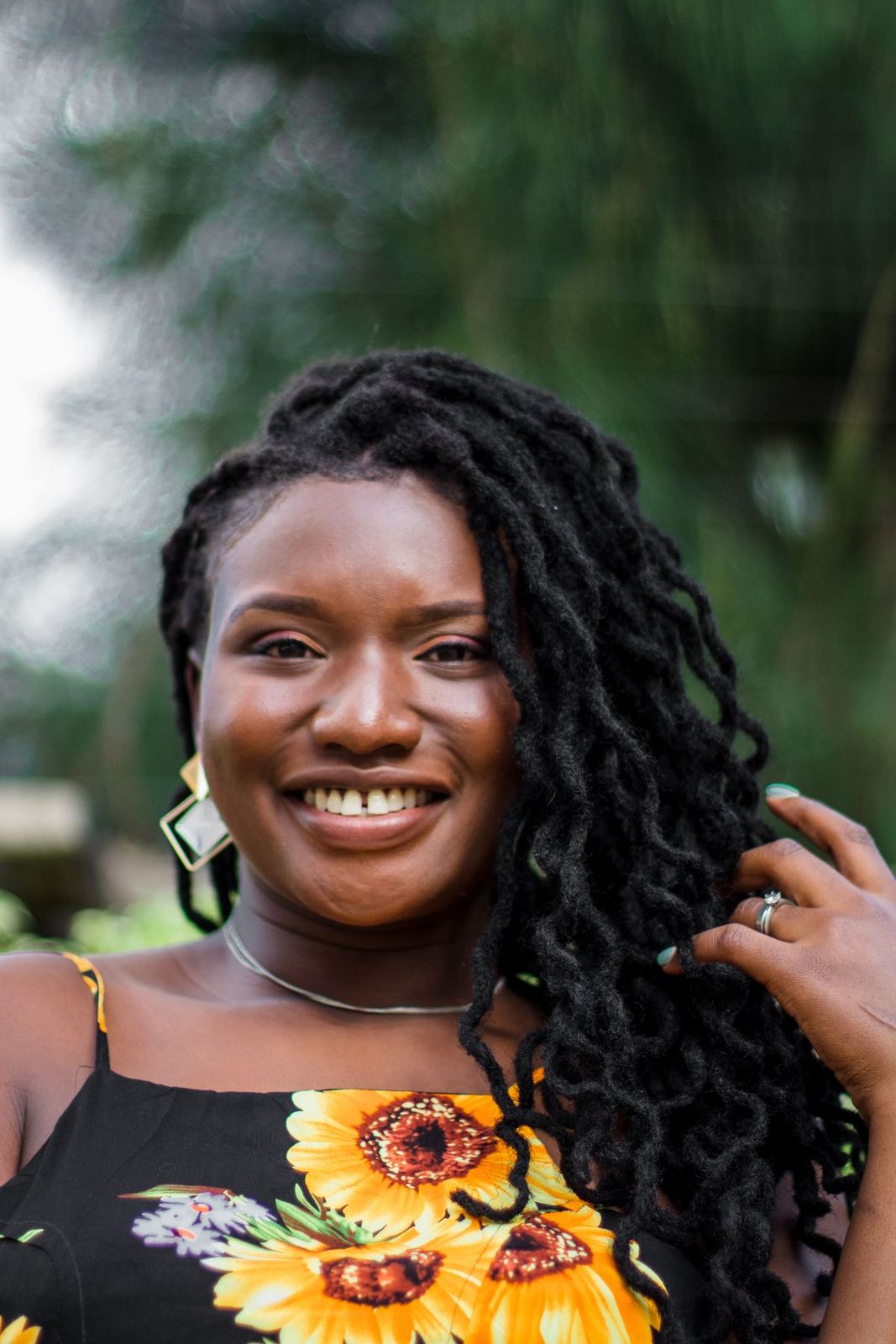 Portrait souriant d’une femme aux locks, en haut fleuri